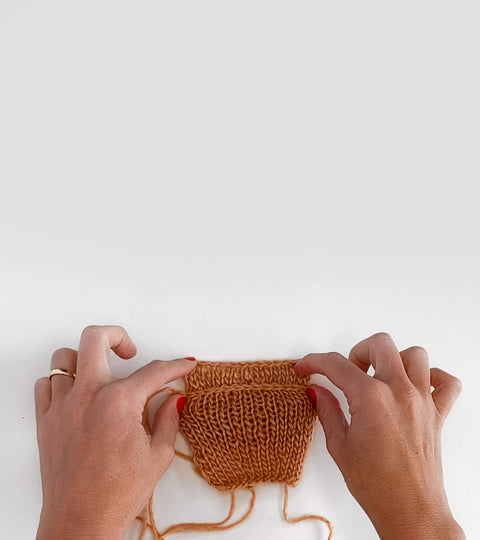 Hand over two swatches of yarn - one bound off using the project's needle and the other using one size larger needle