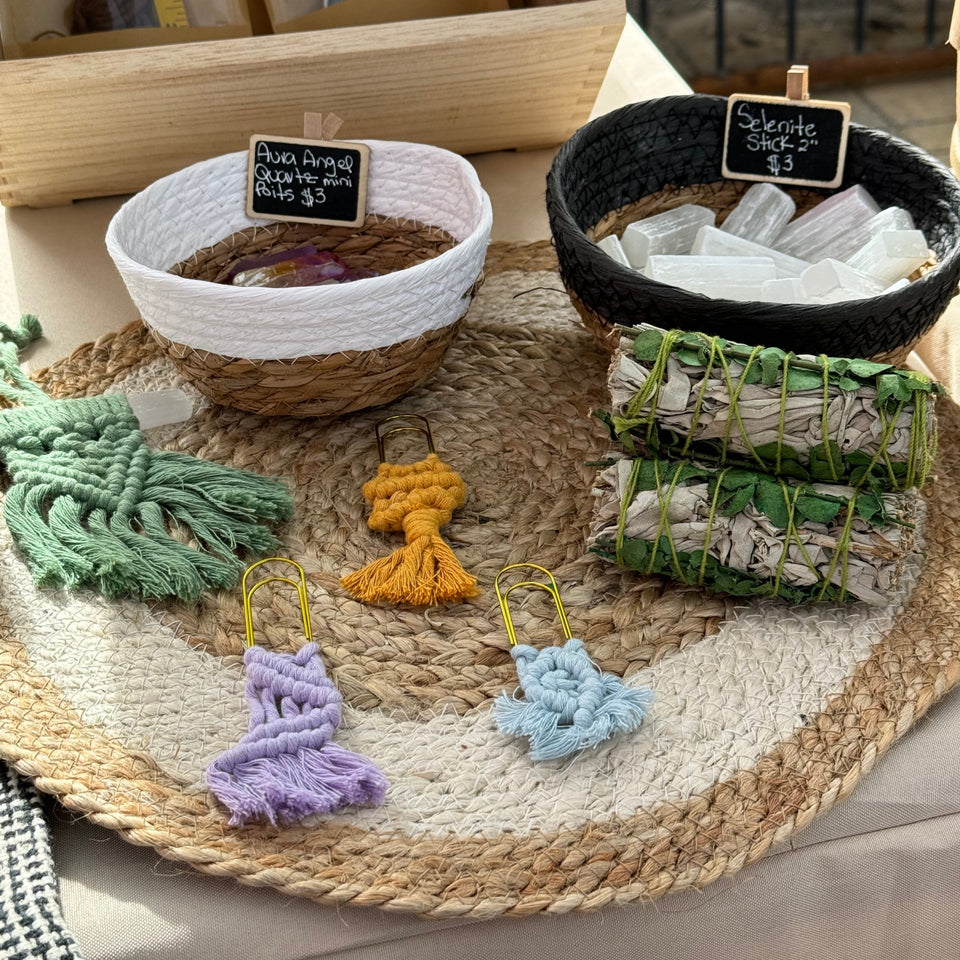 farmers market table set up: three macrame clips with two bowls full of stones over a table